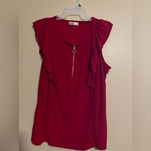 Red top, with Zippper closure. Ruffle sleeves.